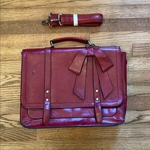 Walasa Red Leather Satchel with Bow Accent, Brass Details, and Black Stitching.